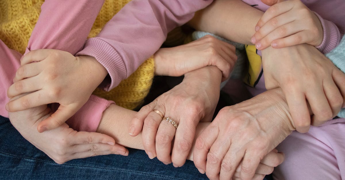 Multiple arms intertwined, symbolizing family unity and support across generations.
